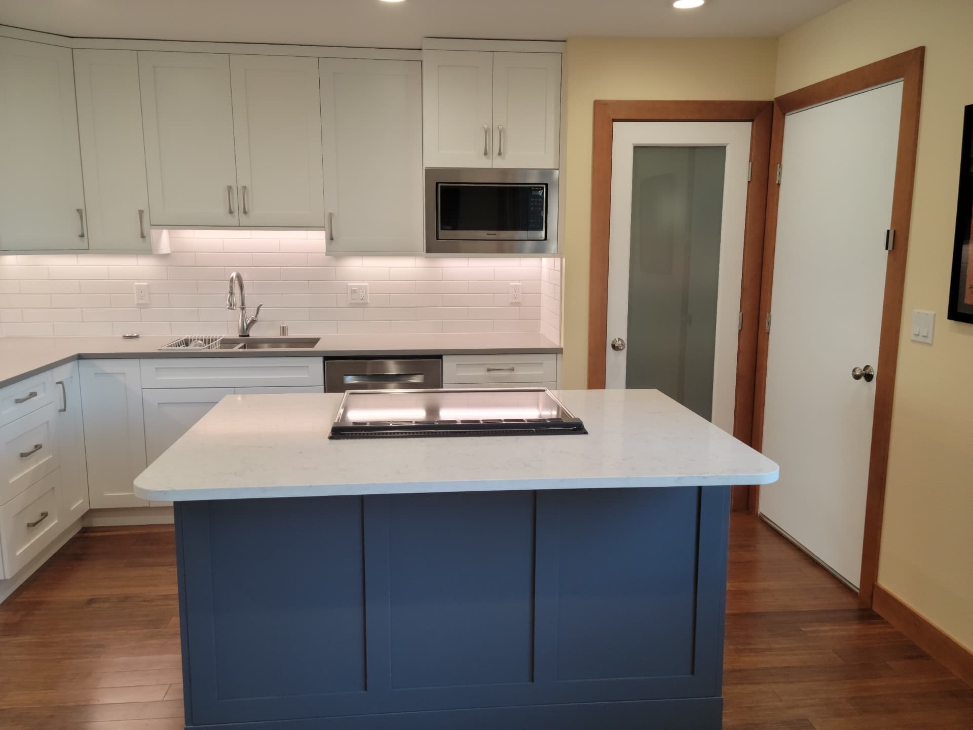Shaker kitchen remodel with navy blue island and quartz countertop